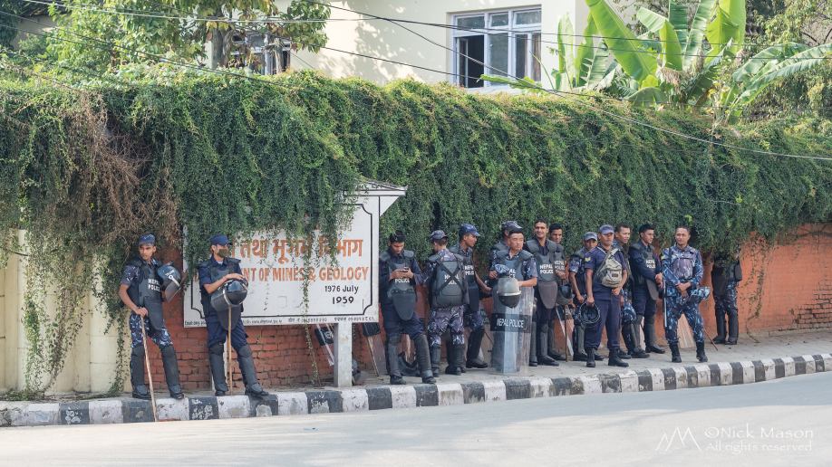 19 Riot police wait on a street corner
