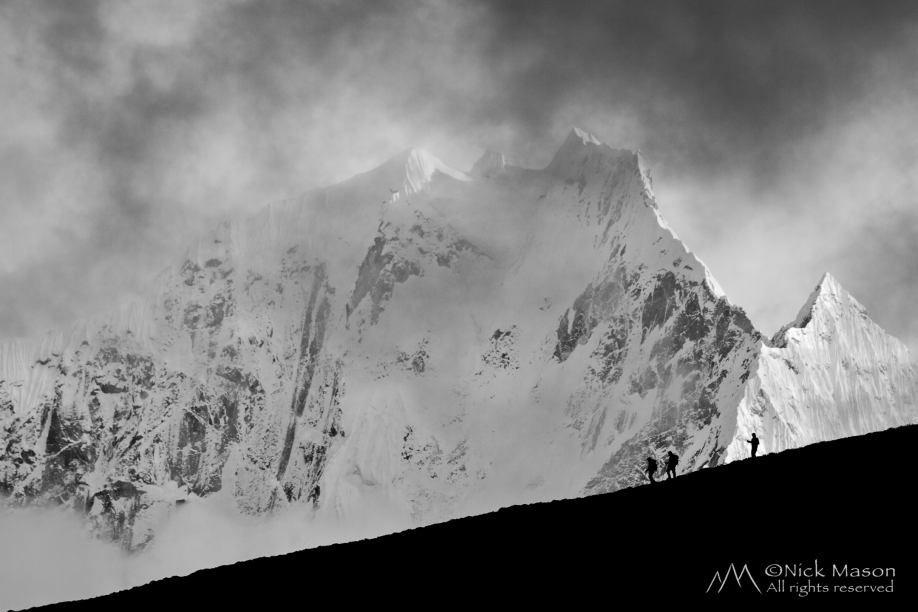 15 Walkers silhouetted against the north face of Thamserku 